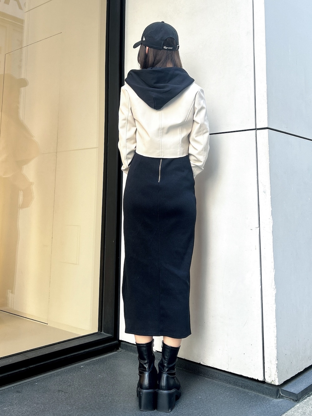 ブラック系のワンピース、ホワイト系のライダースジャケット、ブラック系のキャップを着用したレディースの秋コーディネートの3枚目の写真