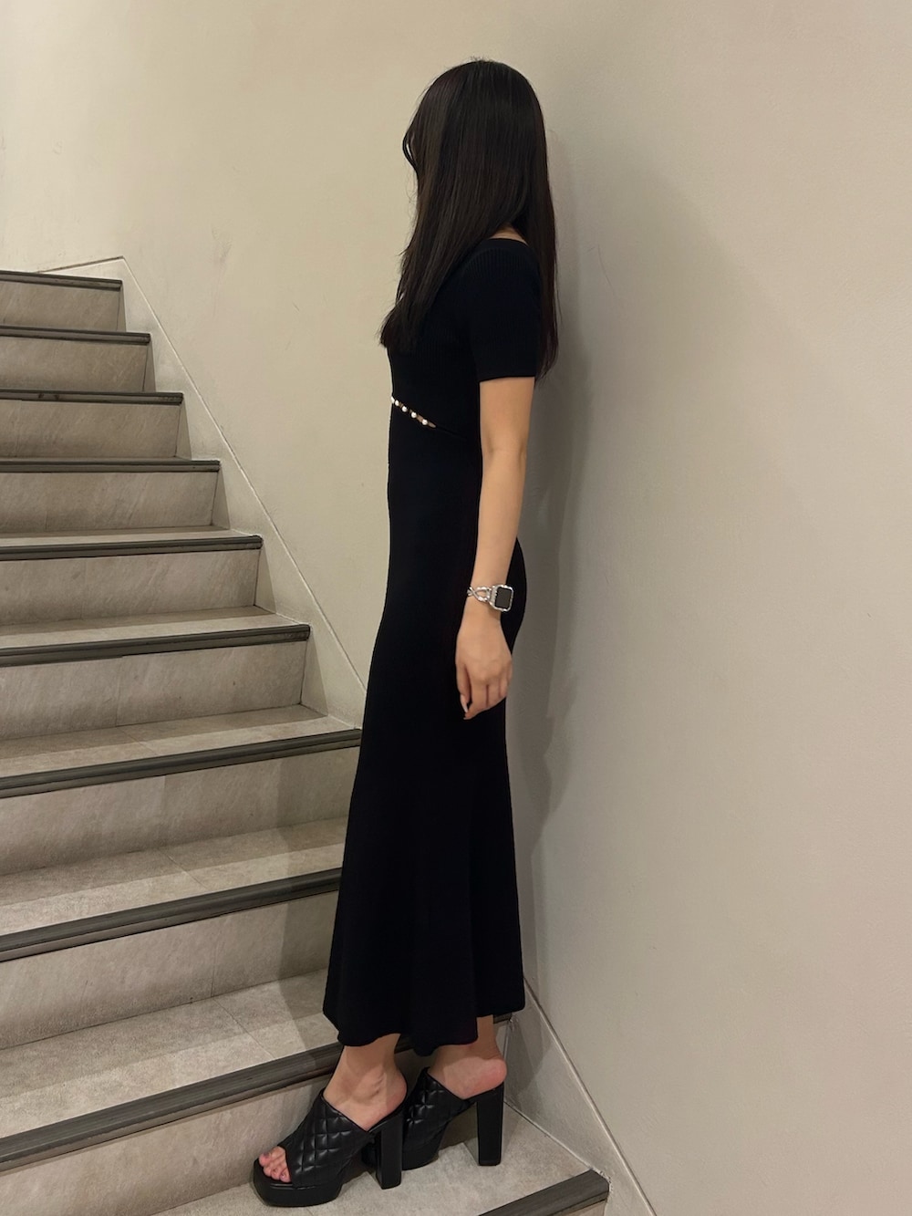 ブラック系のワンピース、ブラック系のサンダル、シルバー系のネックレスを着用したレディースの夏コーディネートの3枚目の写真