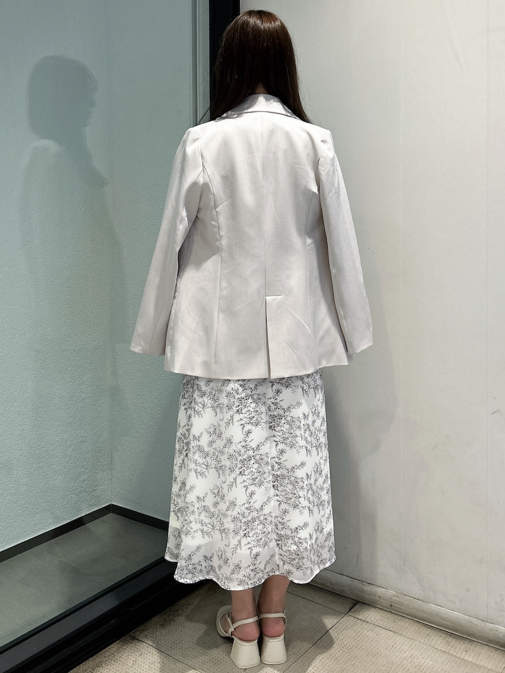 ホワイト系のテーラードジャケット、ホワイト系のシャツワンピース、ホワイト系のハンドバッグを着用したレディースの春コーディネートの4枚目の写真