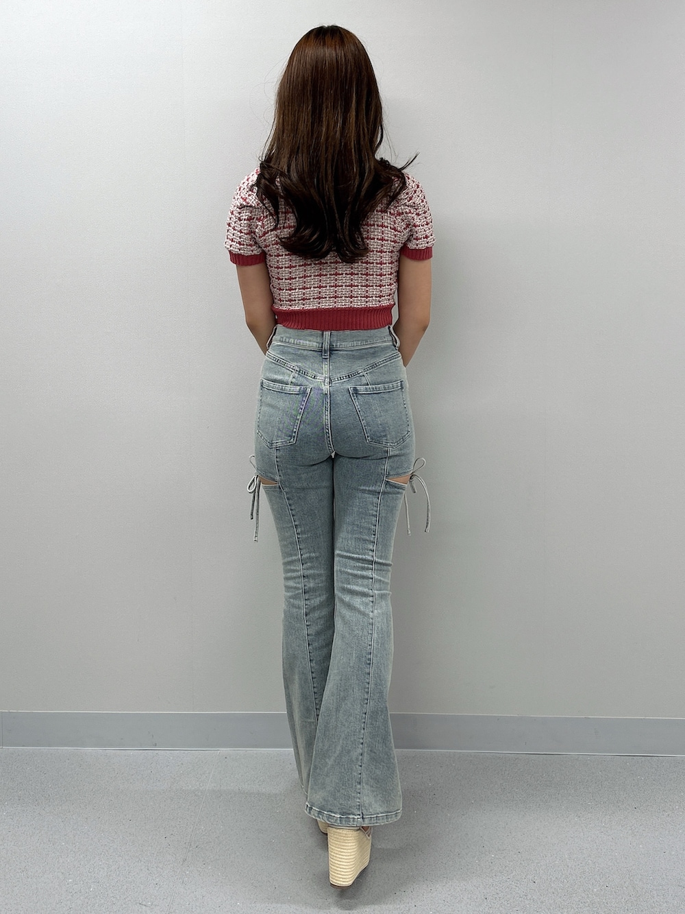 ブルー系のデニムパンツ、ホワイト系のサンダル、ピンク系のニット/セーターを着用したレディースの春コーディネートの2枚目の写真