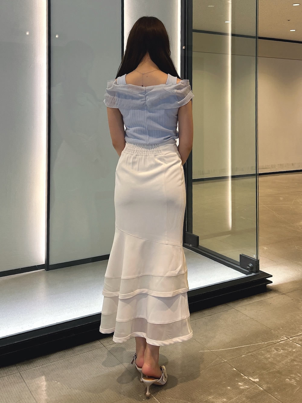 ホワイト系のスカート、ブルー系のTシャツ/カットソーを着用したレディースの春コーディネートの3枚目の写真