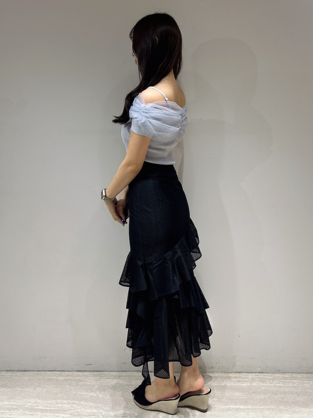 ブラック系のスカート、ブルー系のニット/セーターを着用したレディースの夏コーディネートの4枚目の写真