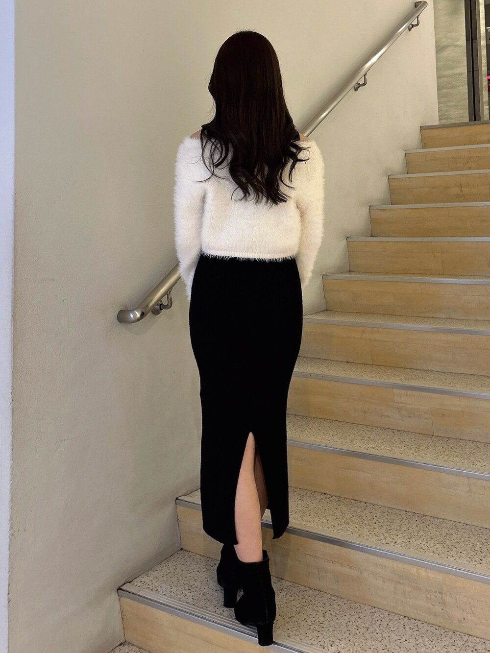 ブラック系のワンピース、ホワイト系のハンドバッグを着用したレディースの冬コーディネートの3枚目の写真