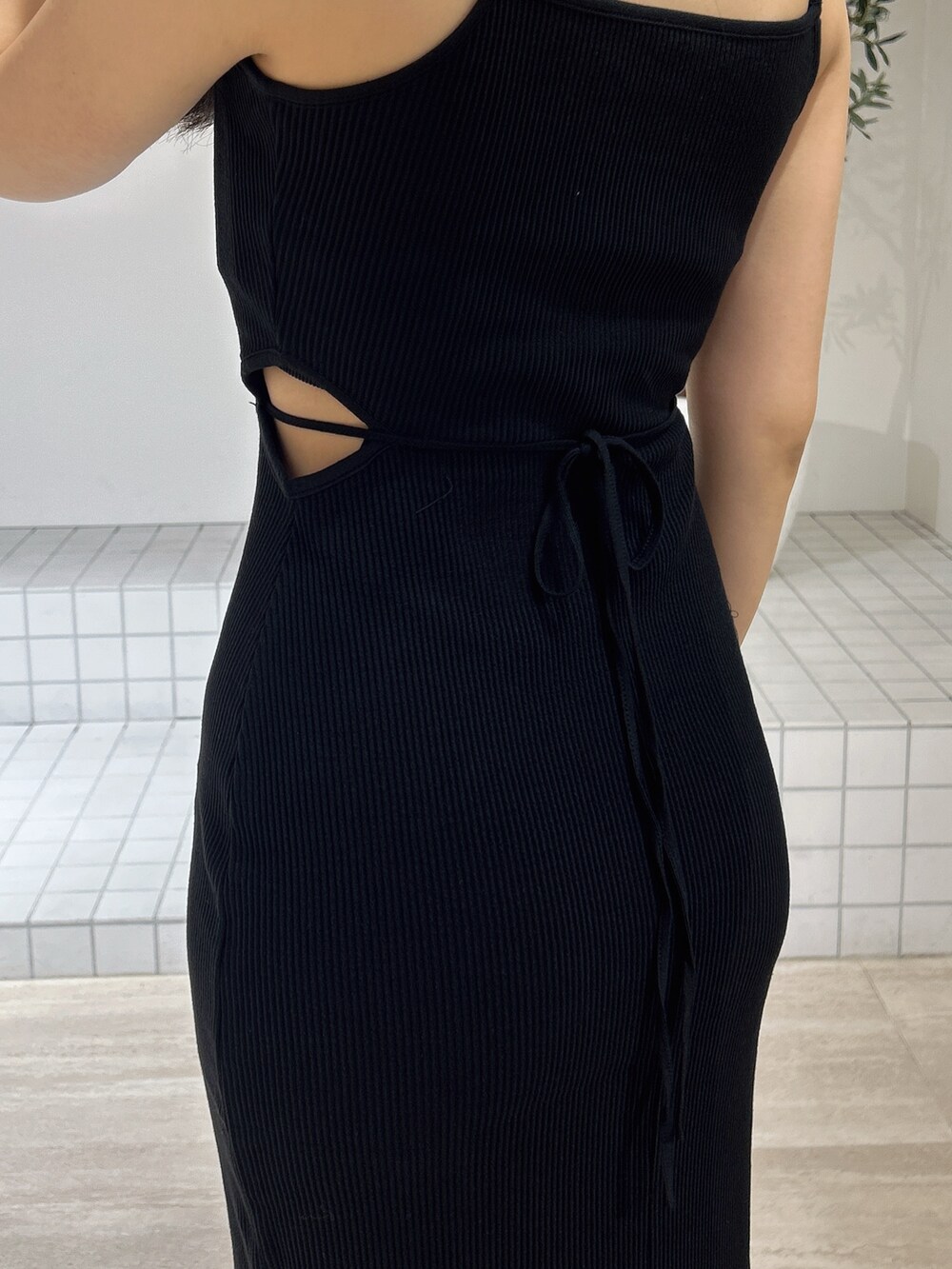 ブラック系のワンピース、ブラック系のサンダル、ベージュ系のキャップを着用したレディースの夏コーディネートの8枚目の写真