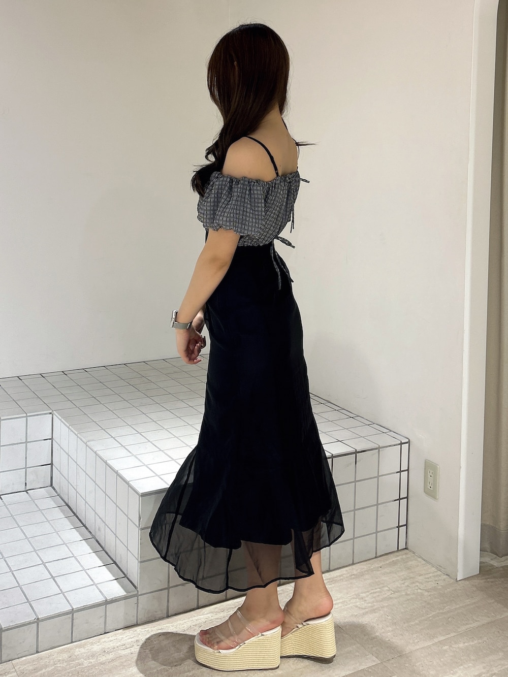 ブラック系のワンピース、ホワイト系のサンダルを着用したレディースの夏コーディネートの3枚目の写真