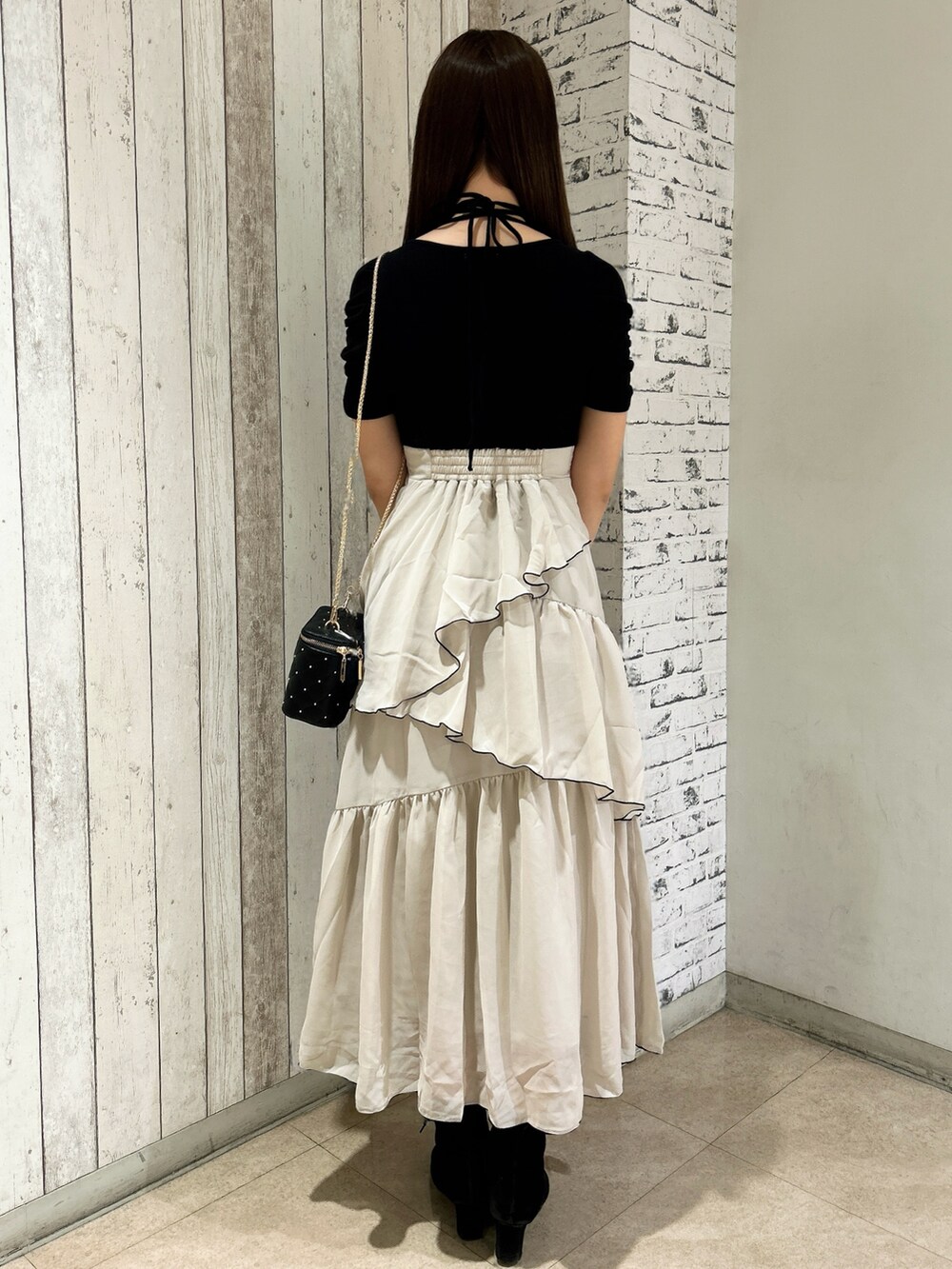 ブラック系のワンピース、ブラック系のショルダーバッグを着用したレディースの春コーディネートの4枚目の写真