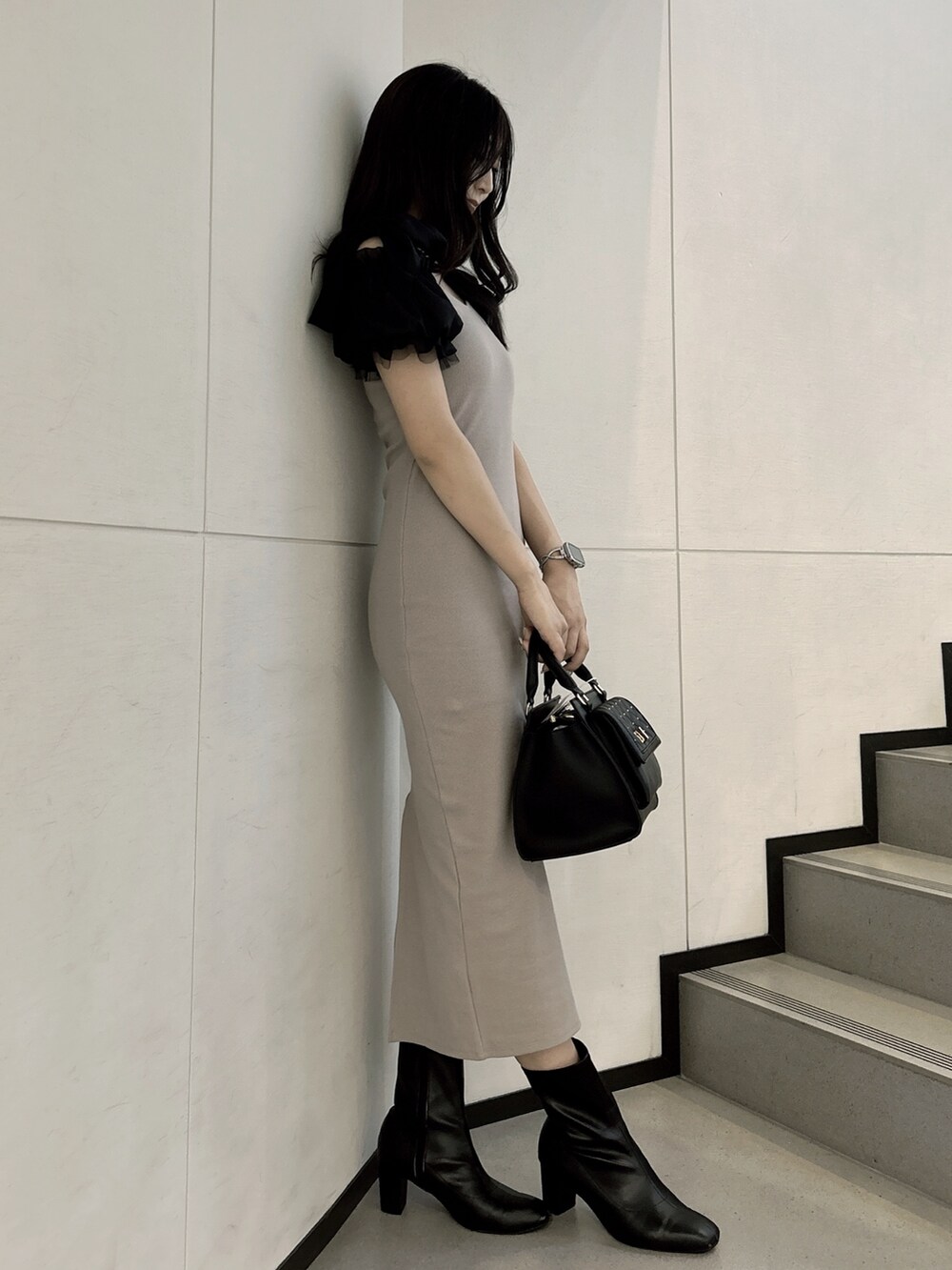 ベージュ系のワンピース、ブラック系のハンドバッグを着用したレディースの秋コーディネートの2枚目の写真