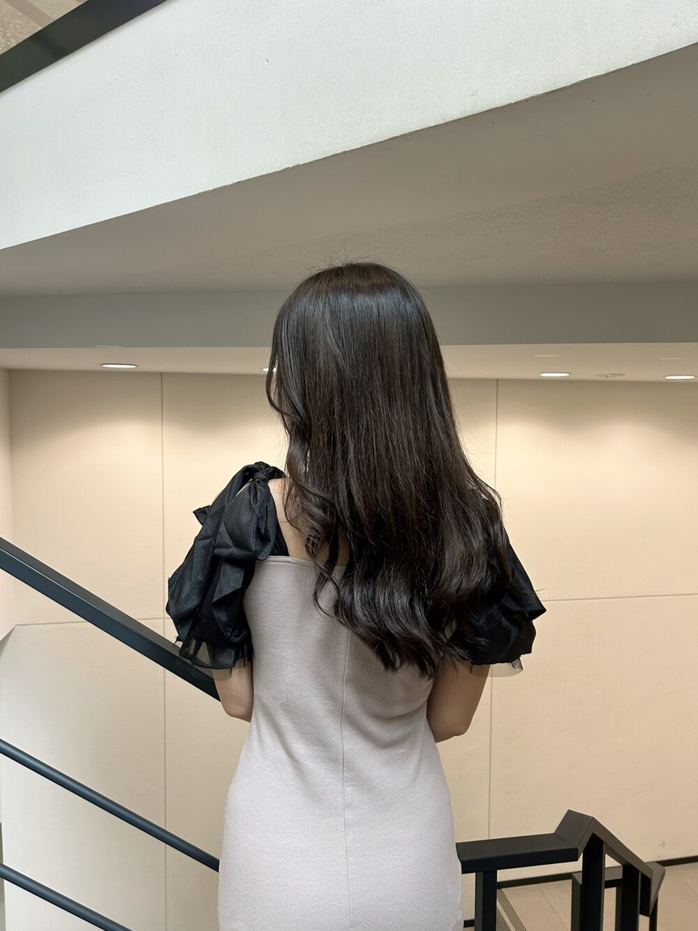 ベージュ系のワンピース、ブラック系のハンドバッグを着用したレディースの秋コーディネートの4枚目の写真