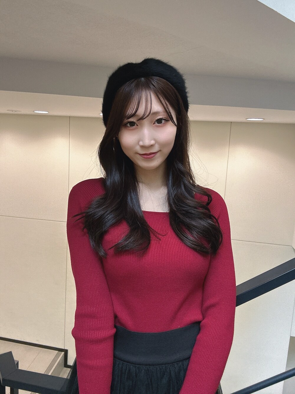 ブラック系のスカート、レッド系のニット/セーター、ブラック系のハンドバッグを着用したレディースの冬コーディネートの4枚目の写真