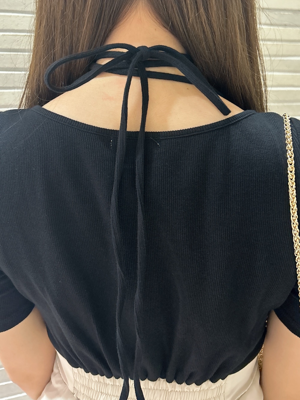 ブラック系のワンピース、ブラック系のショルダーバッグを着用したレディースの春コーディネートの7枚目の写真