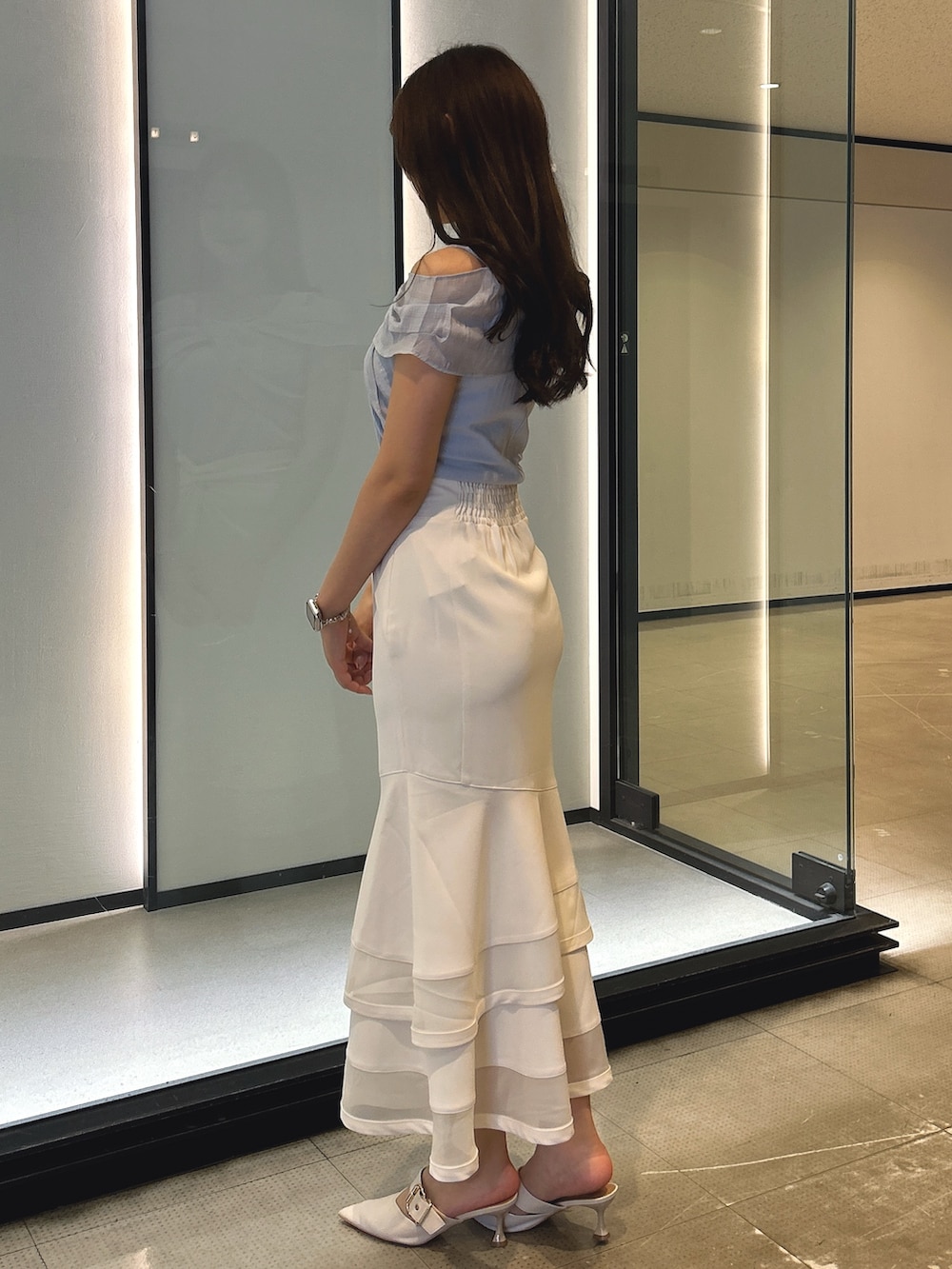 ホワイト系のスカート、ブルー系のTシャツ/カットソーを着用したレディースの春コーディネートの2枚目の写真