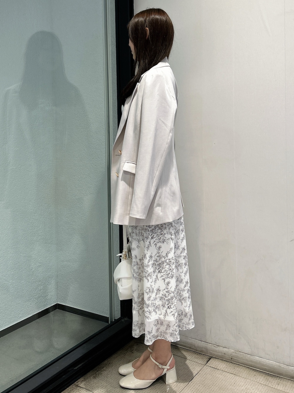 ホワイト系のテーラードジャケット、ホワイト系のシャツワンピース、ホワイト系のハンドバッグを着用したレディースの春コーディネートの3枚目の写真