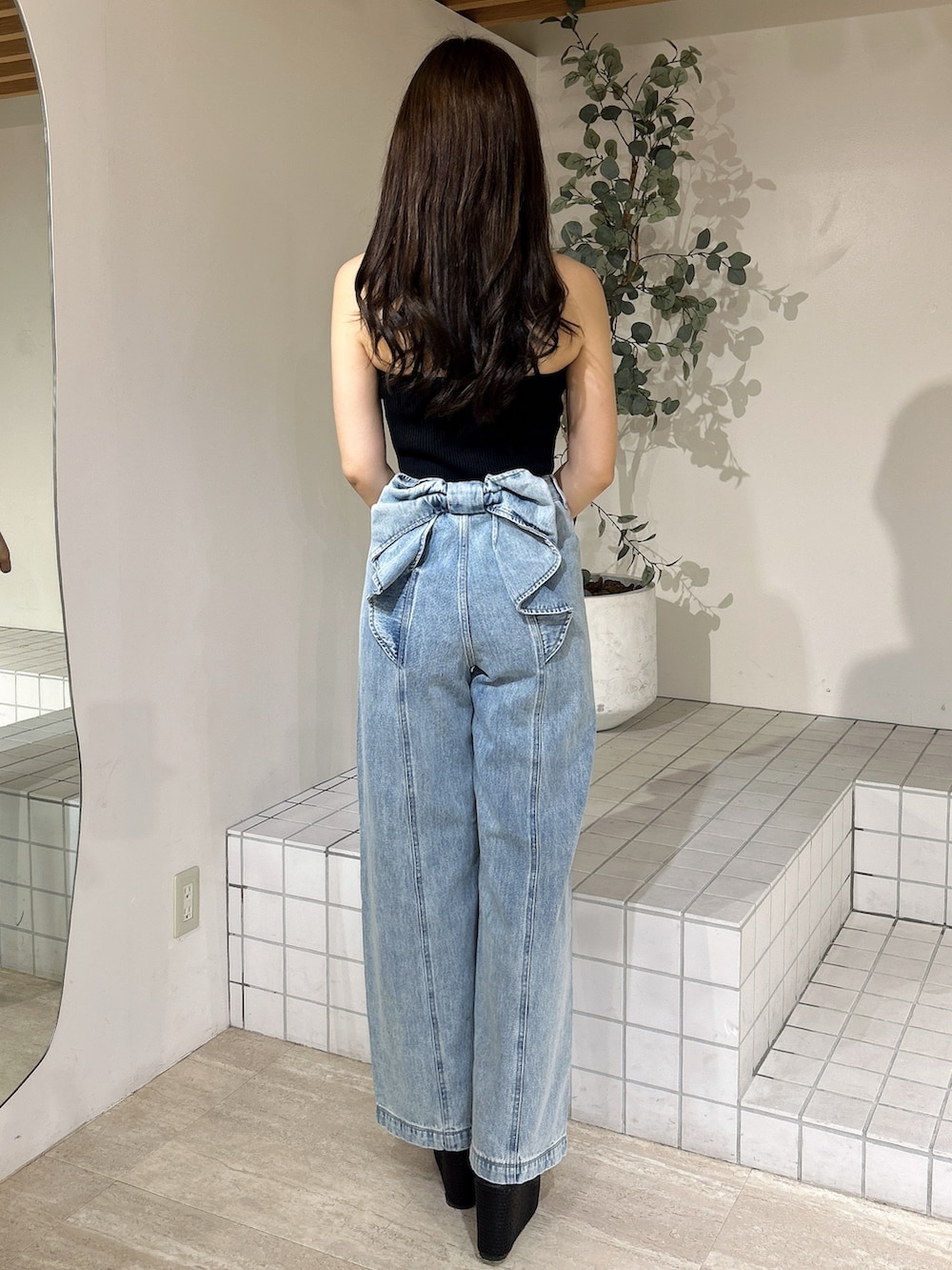 ブルー系のデニムパンツ、ブラック系のキャミソール、ブラック系のサンダルを着用したレディースの夏コーディネートの5枚目の写真