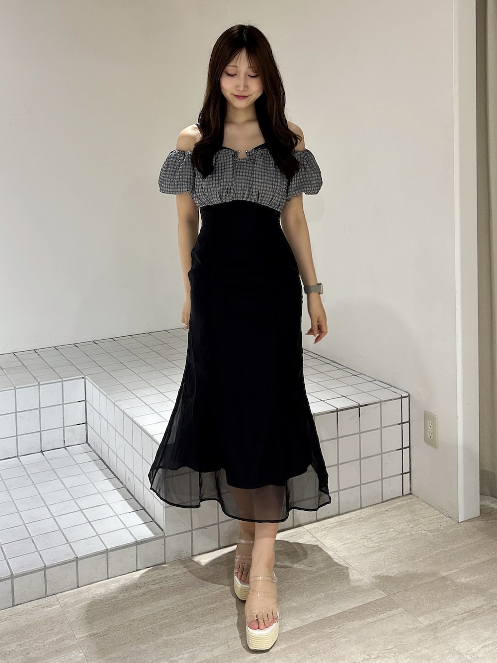 ブラック系のワンピース、ホワイト系のサンダルを着用したレディースの夏コーディネートの2枚目の写真