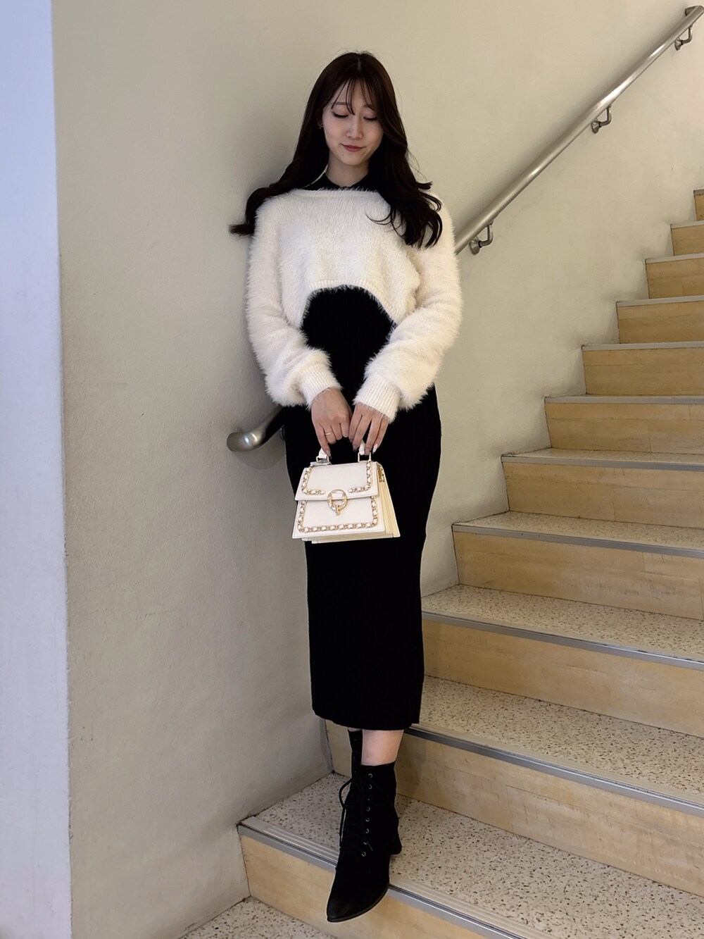 ブラック系のワンピース、ホワイト系のハンドバッグを着用したレディースの冬コーディネートの4枚目の写真