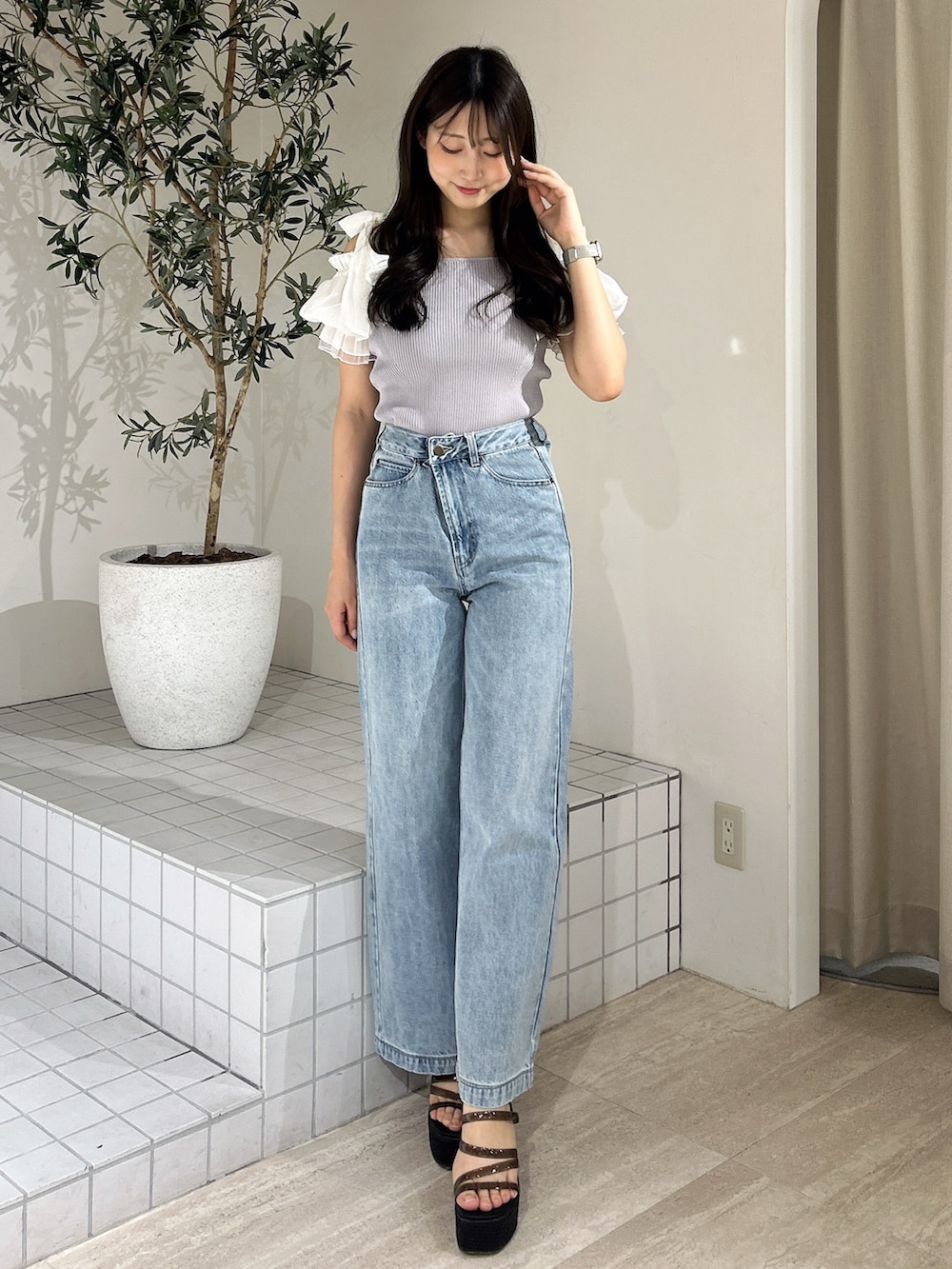 ブルー系のデニムパンツ、ブルー系のニット/セーター、ブラック系のサンダルを着用したレディースの夏コーディネートの3枚目の写真