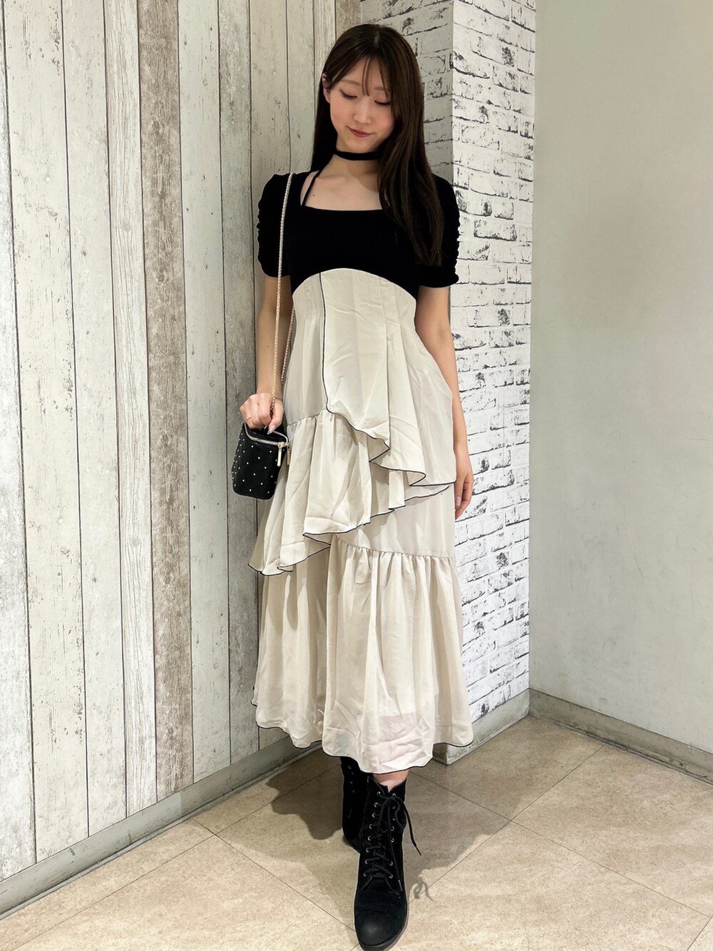 ブラック系のワンピース、ブラック系のショルダーバッグを着用したレディースの春コーディネートの2枚目の写真