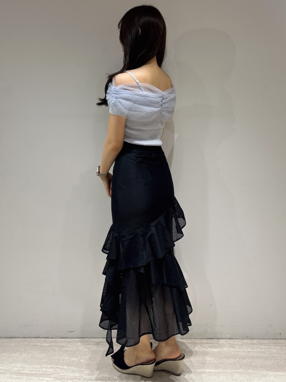 ブラック系のスカート、ブルー系のニット/セーターを着用したレディースの夏コーディネートの3枚目の写真