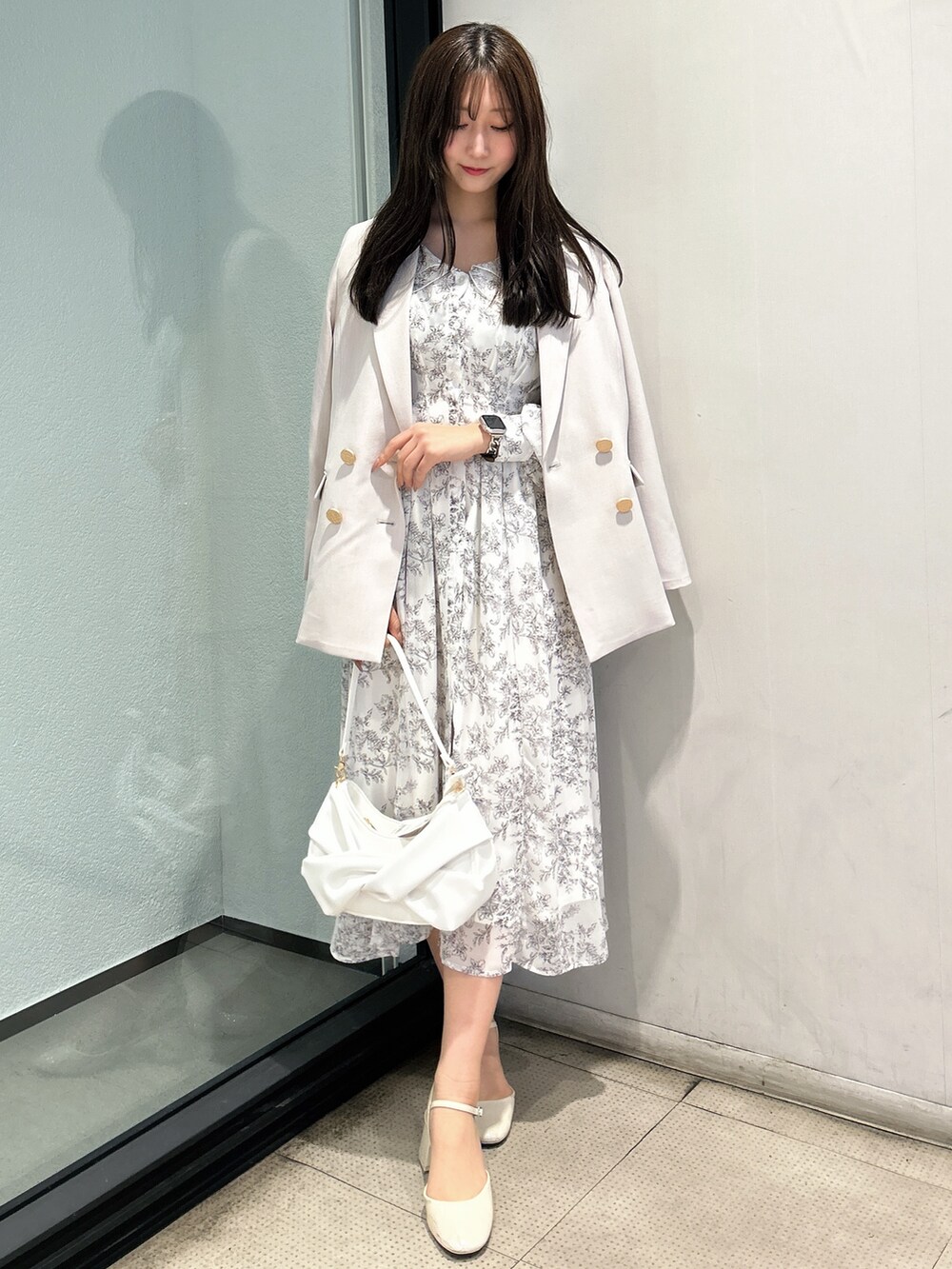 ホワイト系のテーラードジャケット、ホワイト系のシャツワンピース、ホワイト系のハンドバッグを着用したレディースの春コーディネートの2枚目の写真
