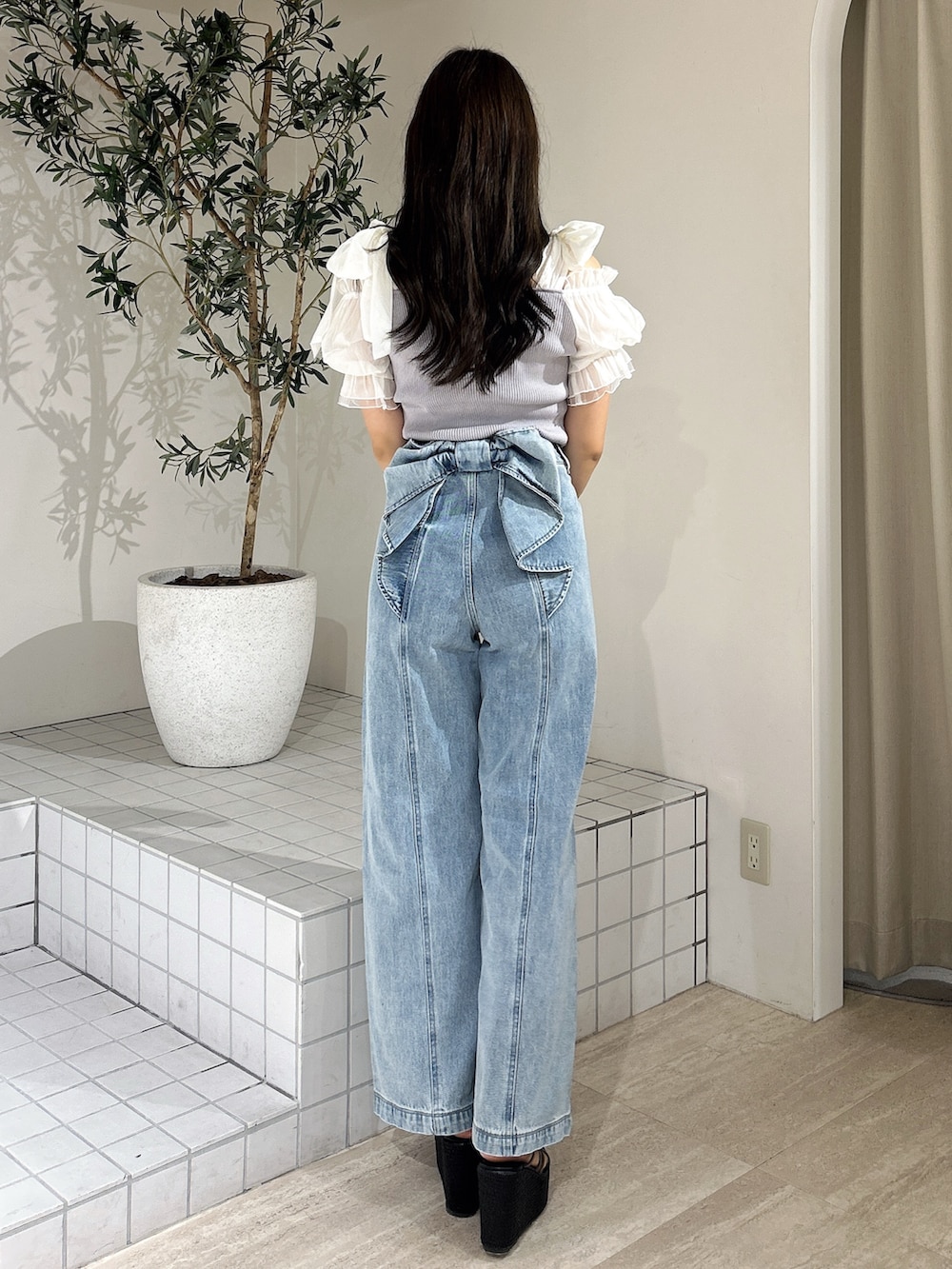 ブルー系のデニムパンツ、ブルー系のニット/セーター、ブラック系のサンダルを着用したレディースの夏コーディネートの5枚目の写真