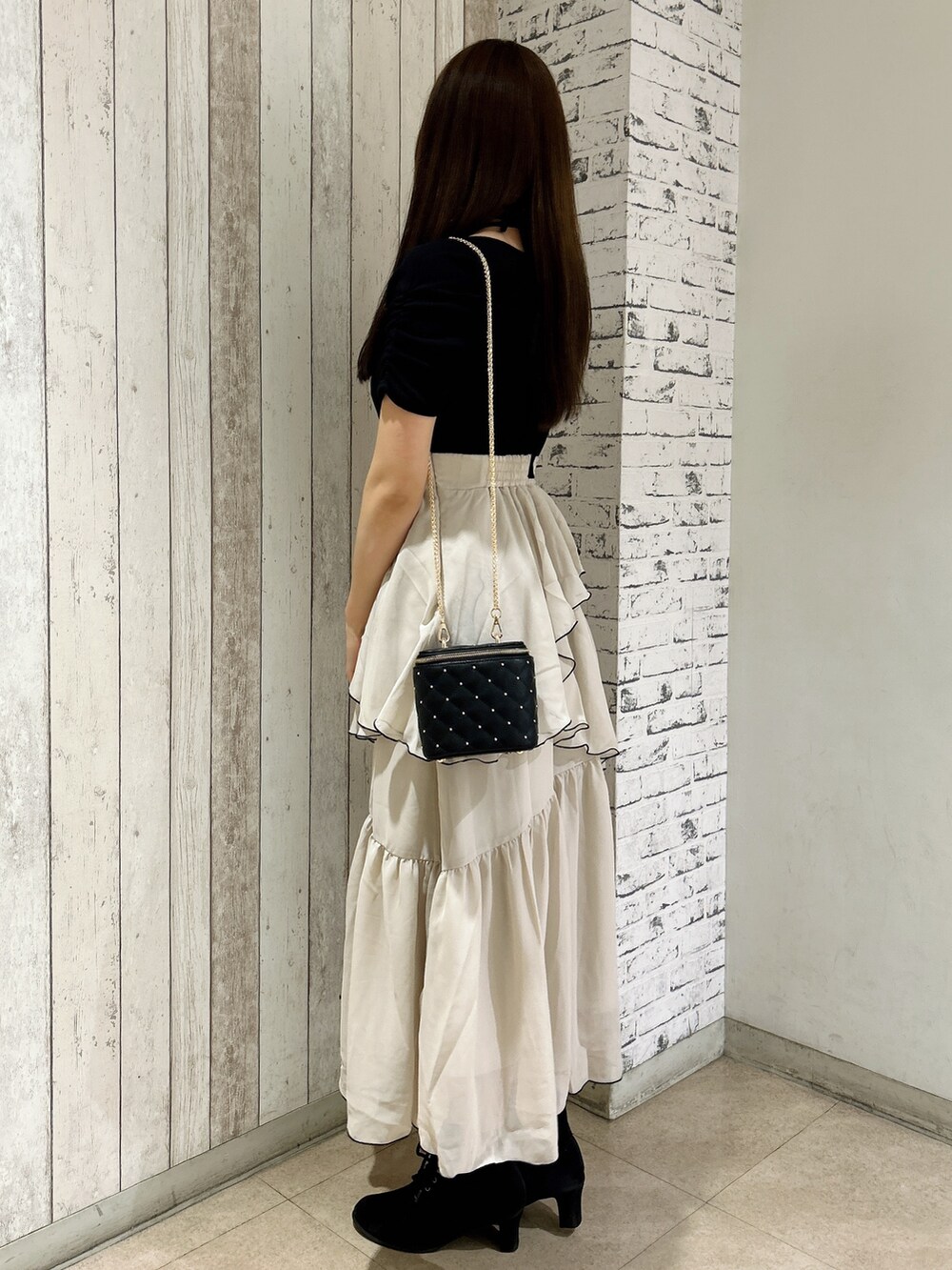 ブラック系のワンピース、ブラック系のショルダーバッグを着用したレディースの春コーディネートの3枚目の写真