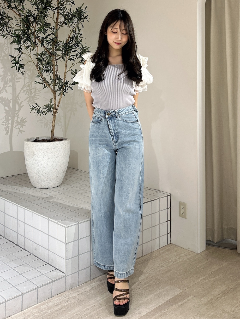 ブルー系のデニムパンツ、ブルー系のニット/セーター、ブラック系のサンダルを着用したレディースの夏コーディネートの2枚目の写真