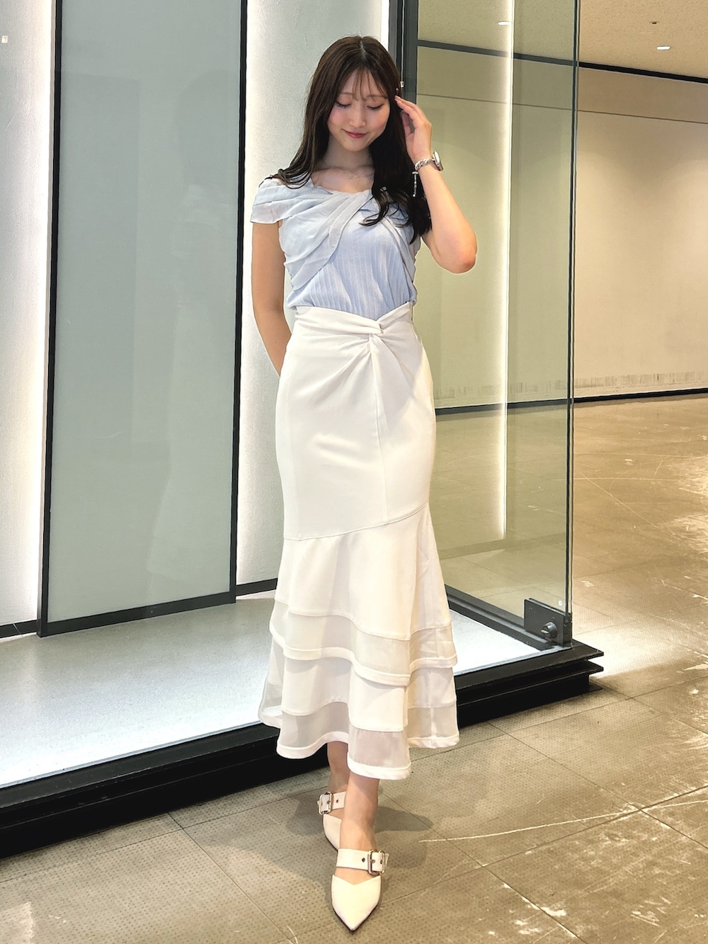 ホワイト系のスカート、ブルー系のTシャツ/カットソーを着用したレディースの春コーディネートの7枚目の写真