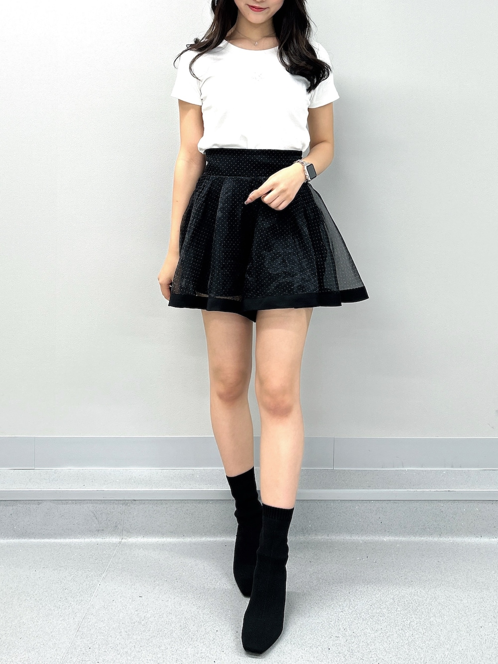 ブラック系のスカート、ホワイト系のTシャツ/カットソーを着用したレディースの春コーディネートの4枚目の写真