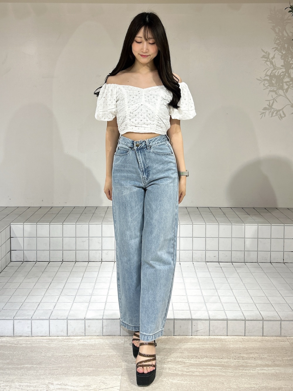 ブルー系のデニムパンツ、ブラック系のサンダル、ホワイト系のシャツ/ブラウスを着用したレディースの夏コーディネートの2枚目の写真