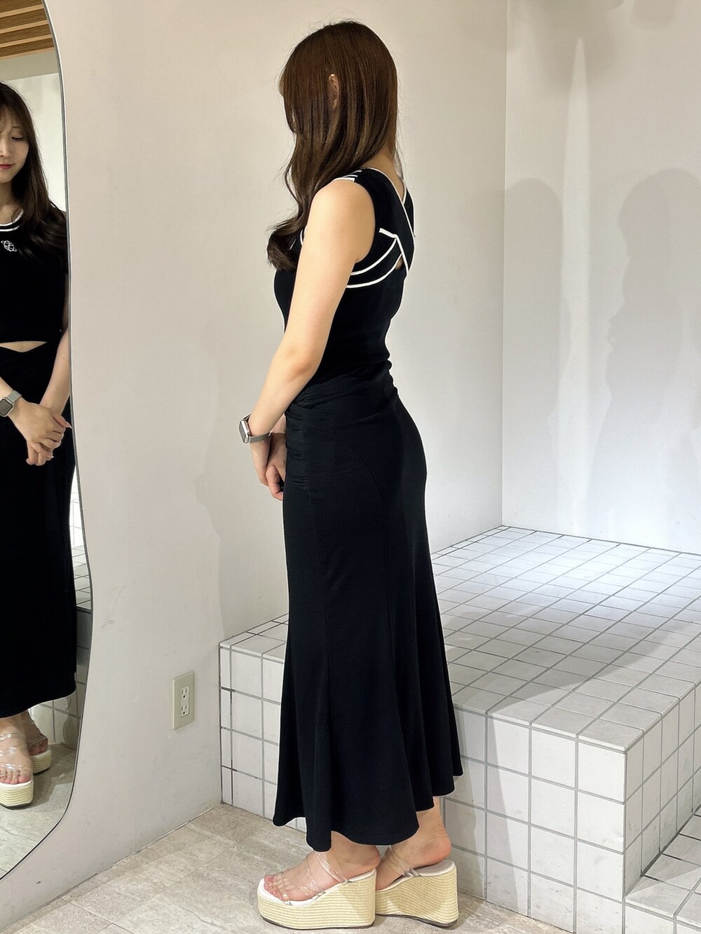 ブラック系のスカート、ホワイト系のサンダル、ブラック系のタンクトップを着用したレディースの夏コーディネートの2枚目の写真