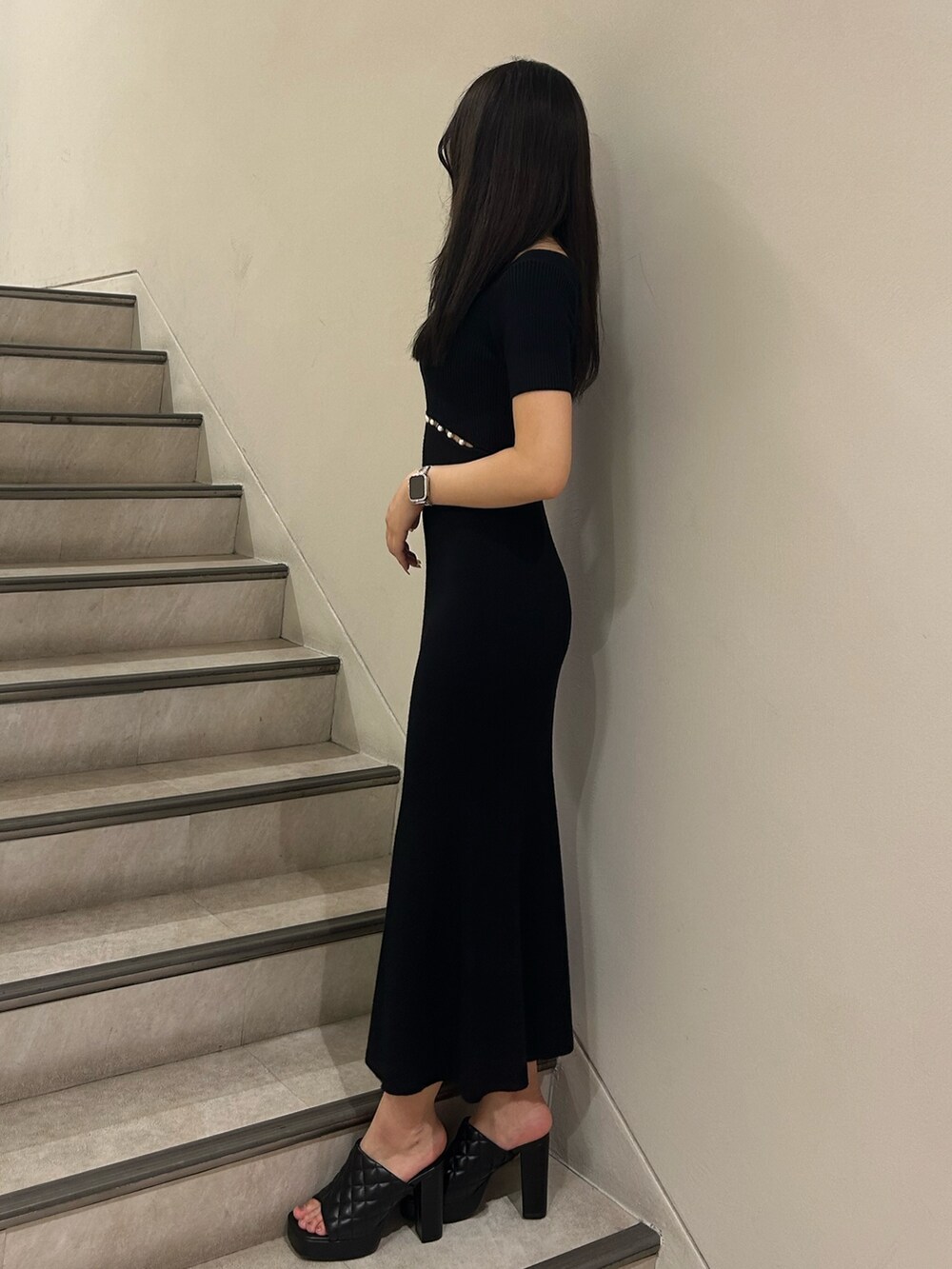 ブラック系のワンピース、ブラック系のサンダル、シルバー系のネックレスを着用したレディースの夏コーディネートの2枚目の写真