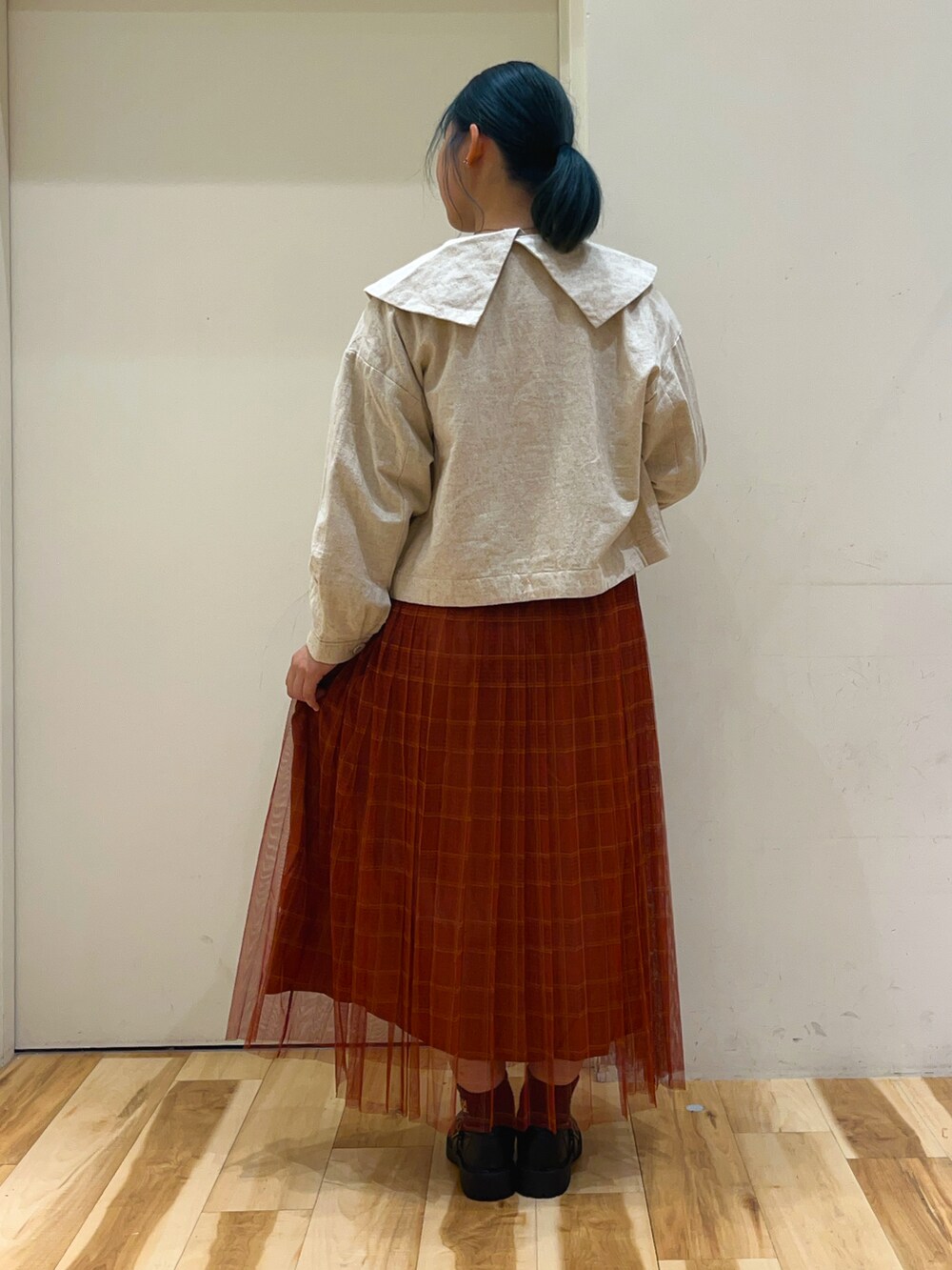 グレー系のTシャツ/カットソー、ホワイト系のノーカラージャケット、レッド系のスカートを着用したレディースの秋コーディネートの2枚目の写真