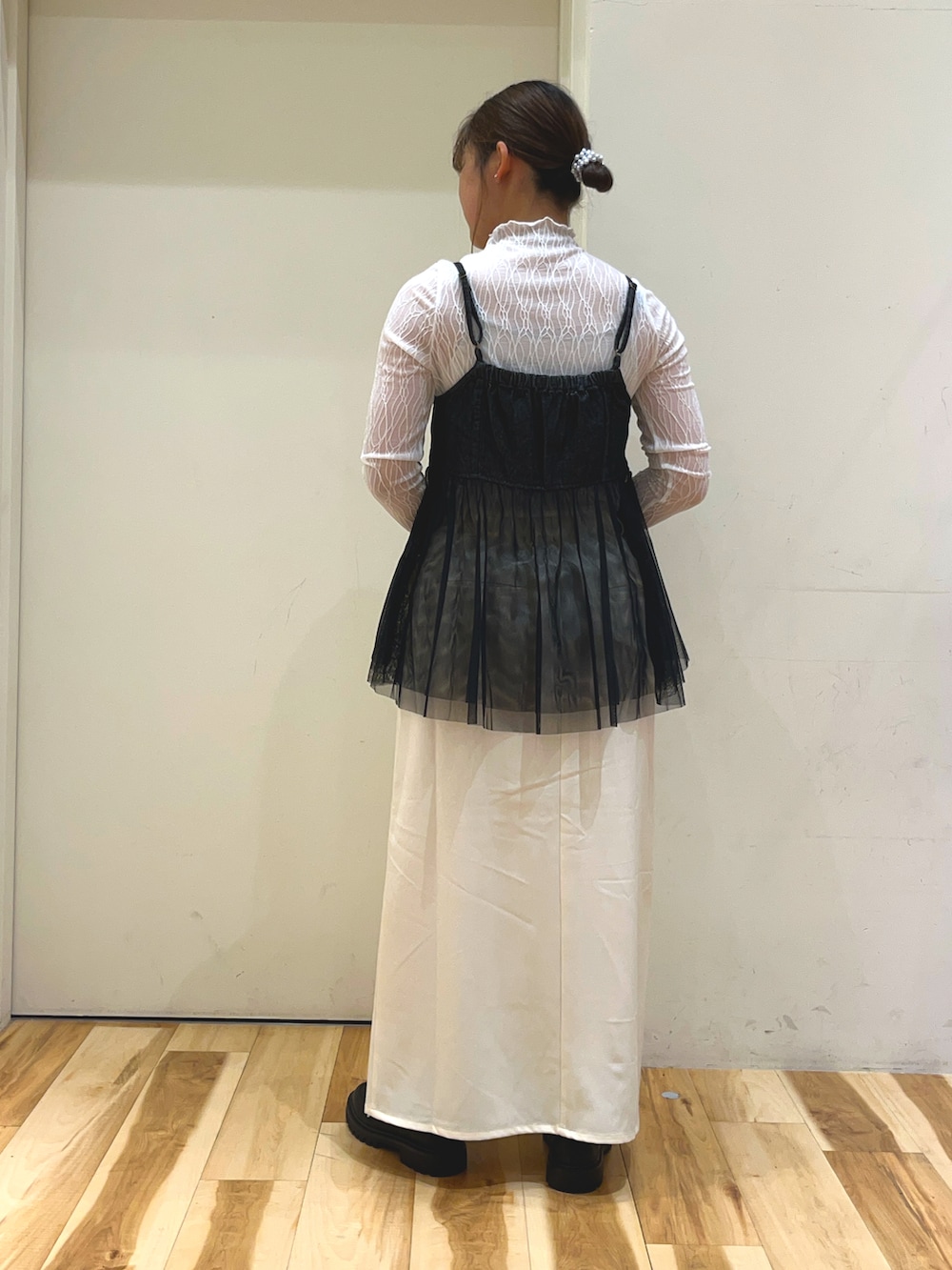 ホワイト系のTシャツ/カットソー、ブラック系のトップス、ホワイト系のスカートを着用したレディースの秋コーディネートの2枚目の写真