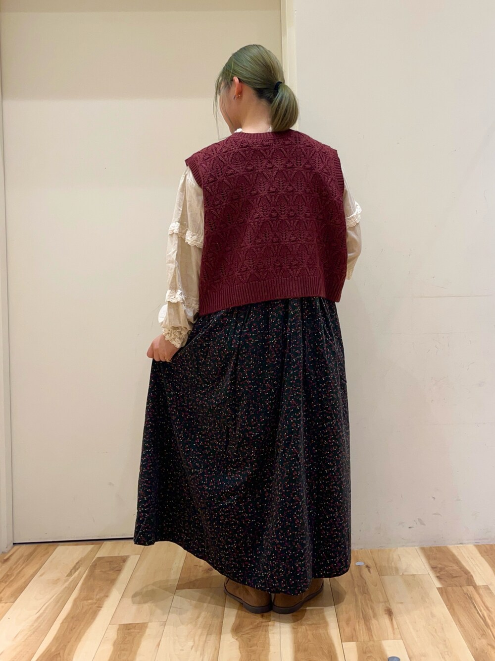ホワイト系のシャツ/ブラウス、レッド系のベスト、グリーン系のワンピースを着用したレディースの秋コーディネートの2枚目の写真