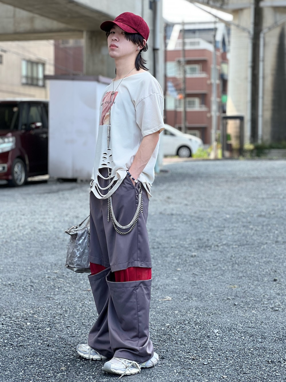 イエロー系のTシャツ/カットソー、シルバー系のバッグ、グレー系のスニーカーを着用したメンズの夏コーディネートの2枚目の写真
