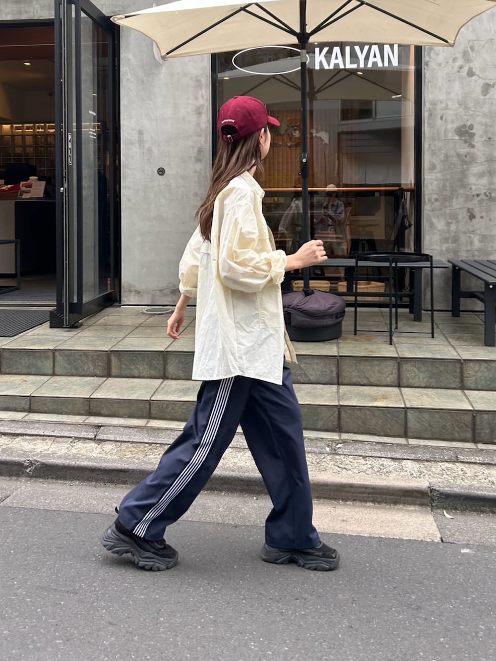 ホワイト系のシャツ/ブラウス、ブルー系のその他パンツ、ブラック系のキャップを着用したレディースの春コーディネートの2枚目の写真