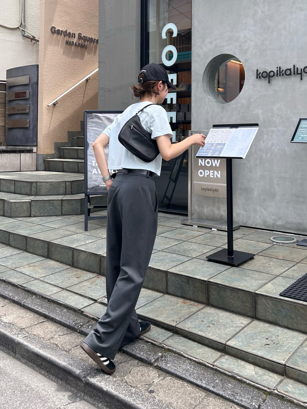 ブルー系のTシャツ/カットソー、グレー系のスラックス、ブラック系のキャップを着用したレディースの夏コーディネートの3枚目の写真