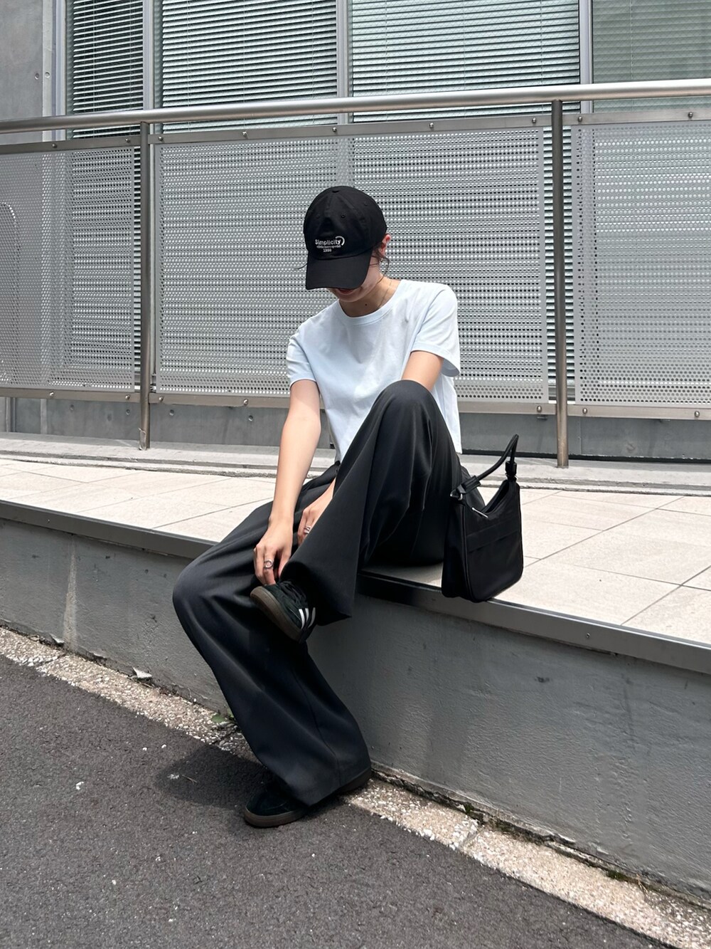 ブルー系のTシャツ/カットソー、グレー系のスラックス、ブラック系のキャップを着用したレディースの夏コーディネートの2枚目の写真