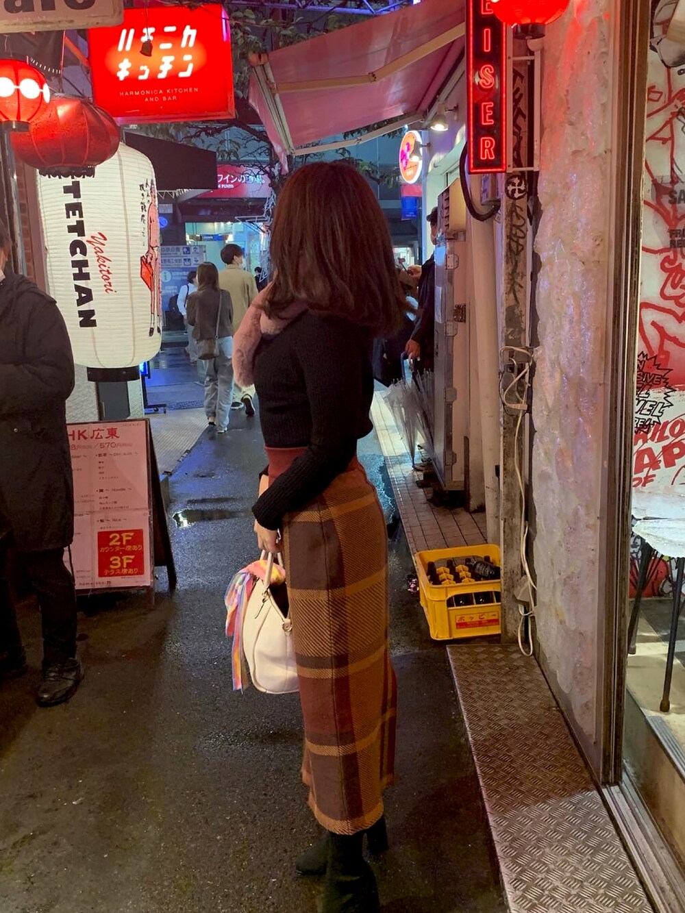 ホワイト系のハンドバッグ、レッド系のスカートを着用したレディースの秋コーディネートの2枚目の写真