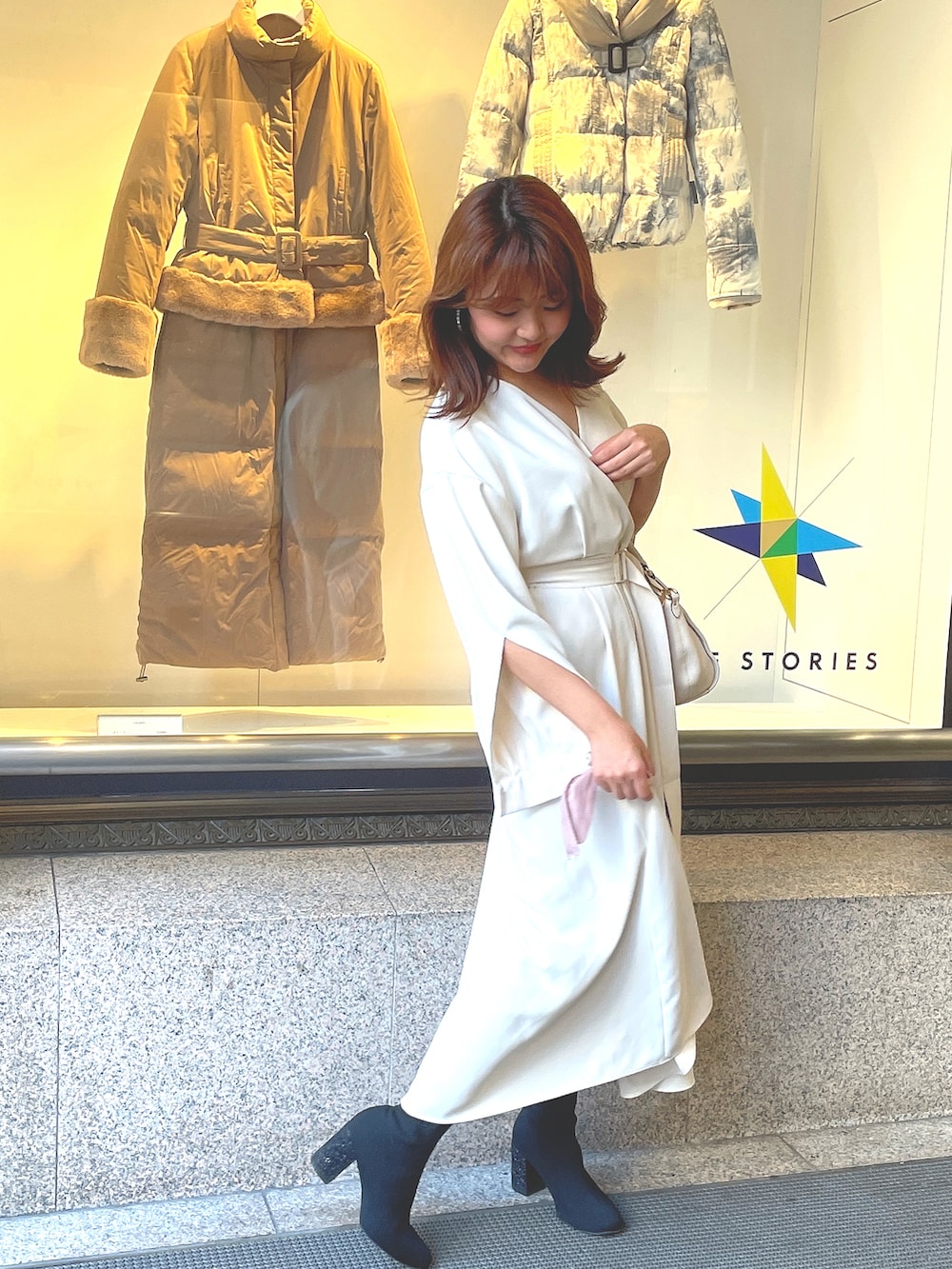 ホワイト系のハンドバッグ、ホワイト系のワンピース/ドレス、シルバー系のピアス（両耳用）を着用したレディースの秋コーディネートの2枚目の写真