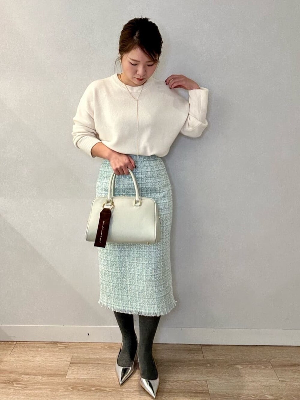 グリーン系のショルダーバッグ、ホワイト系のニット/セーター、イエロー系のその他アウターを着用したレディースの冬コーディネートの4枚目の写真
