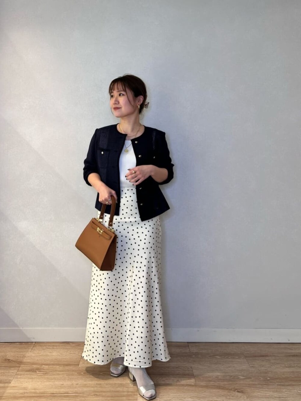 ホワイト系のスカート、イエロー系のショルダーバッグ、ブルー系のノーカラージャケットを着用したレディースの春コーディネートの5枚目の写真