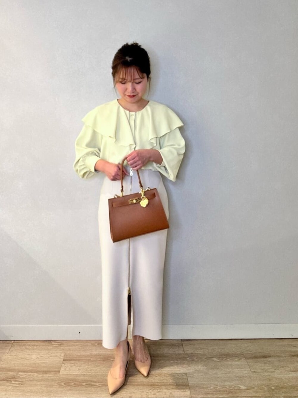 ブラック系のスカート、イエロー系のシャツ/ブラウス、イエロー系のショルダーバッグを着用したレディースの春コーディネートの2枚目の写真