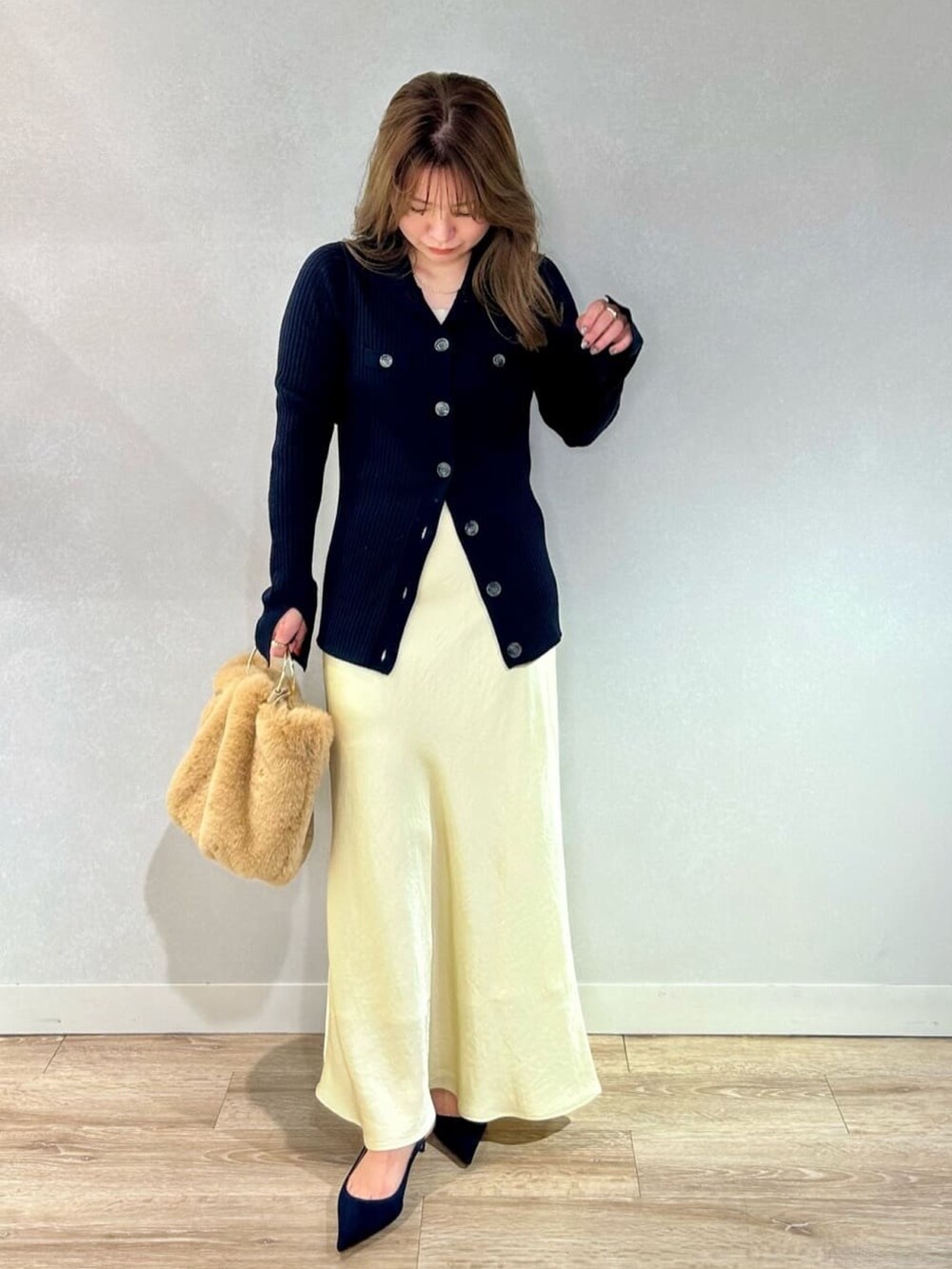 イエロー系のスカート、ベージュ系のショルダーバッグ、ブルー系のカーディガン/ボレロを着用したレディースの冬コーディネートの3枚目の写真