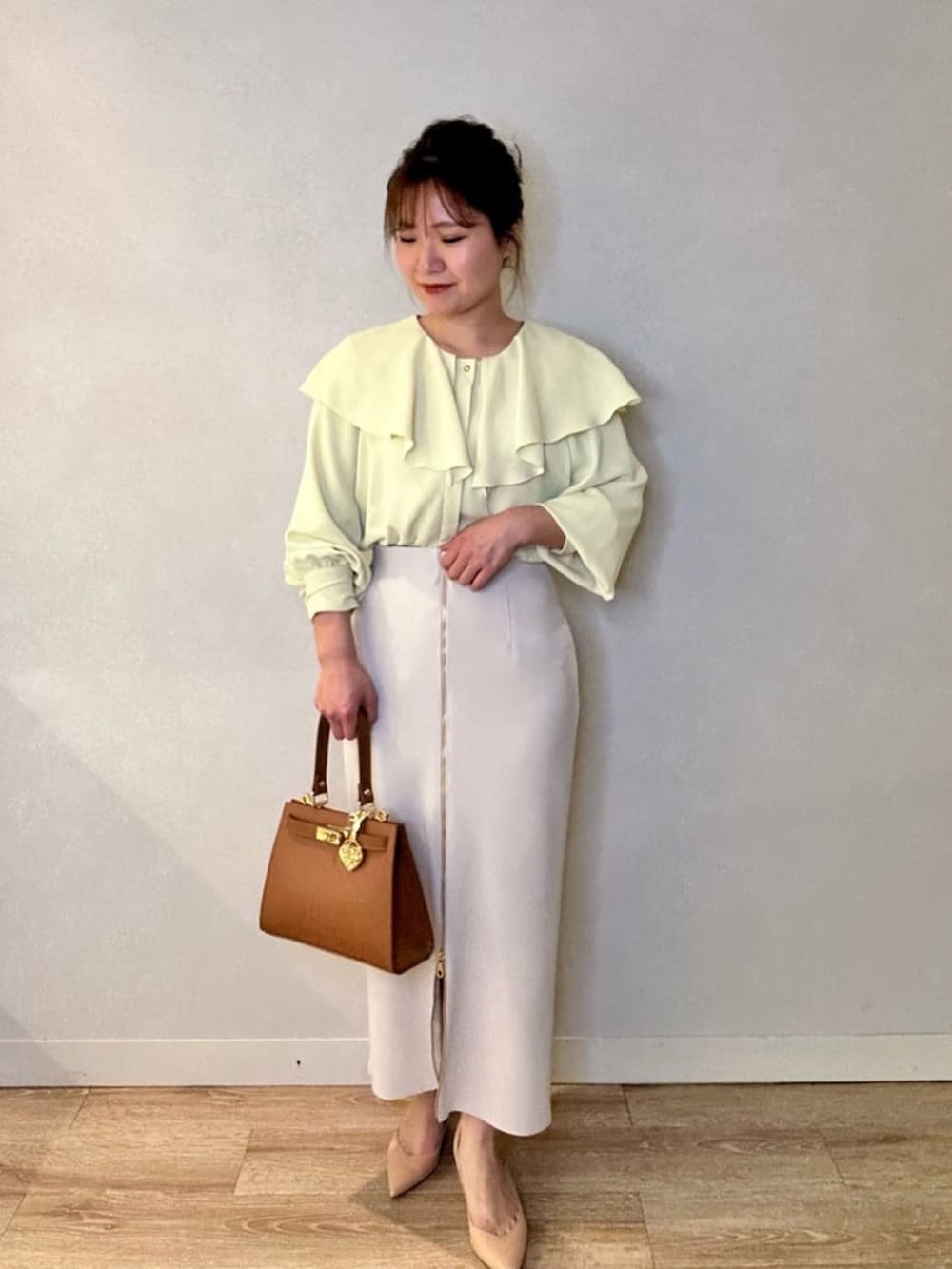 ブラック系のスカート、イエロー系のシャツ/ブラウス、イエロー系のショルダーバッグを着用したレディースの春コーディネートの6枚目の写真