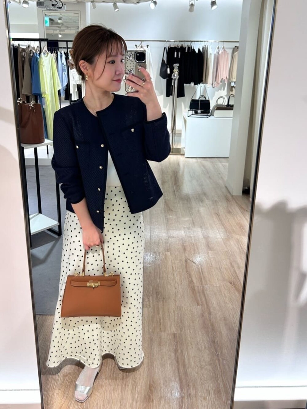 ホワイト系のスカート、イエロー系のショルダーバッグ、ブルー系のノーカラージャケットを着用したレディースの春コーディネートの7枚目の写真