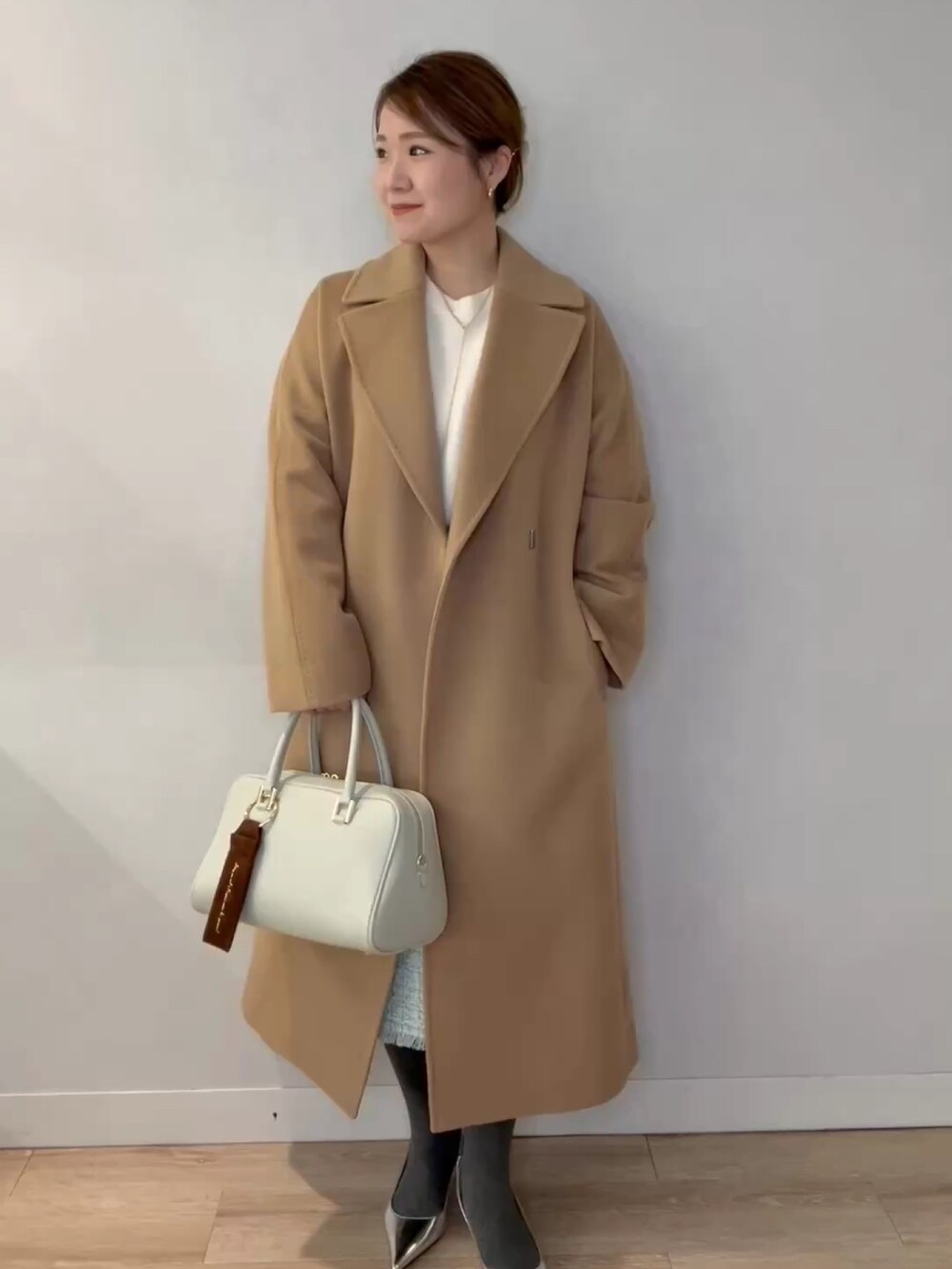 グリーン系のショルダーバッグ、ホワイト系のニット/セーター、イエロー系のその他アウターを着用したレディースの冬コーディネートの5枚目の写真