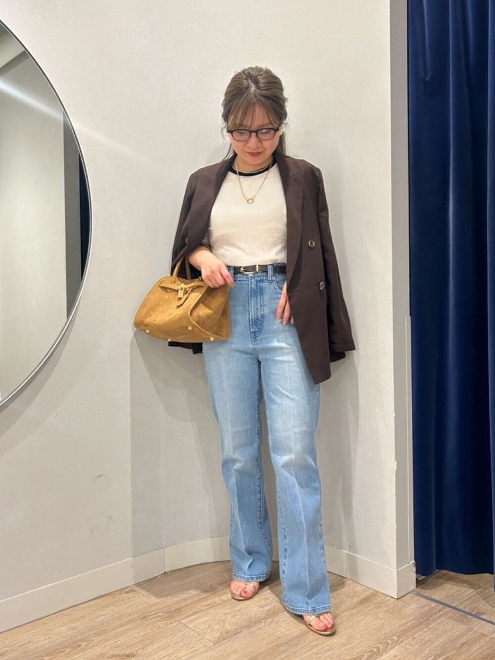 ブルー系のデニムパンツ、イエロー系のトートバッグ、ブラウン系のテーラードジャケットを着用したレディースの夏コーディネートの6枚目の写真