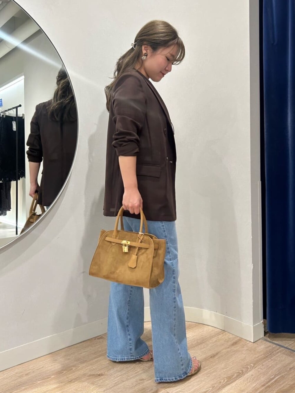 ブルー系のデニムパンツ、イエロー系のトートバッグ、ブラウン系のテーラードジャケットを着用したレディースの夏コーディネートの4枚目の写真