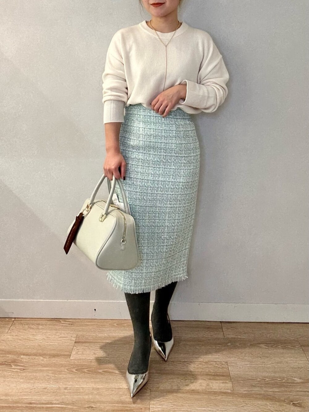 グリーン系のショルダーバッグ、ホワイト系のニット/セーター、イエロー系のその他アウターを着用したレディースの冬コーディネートの2枚目の写真